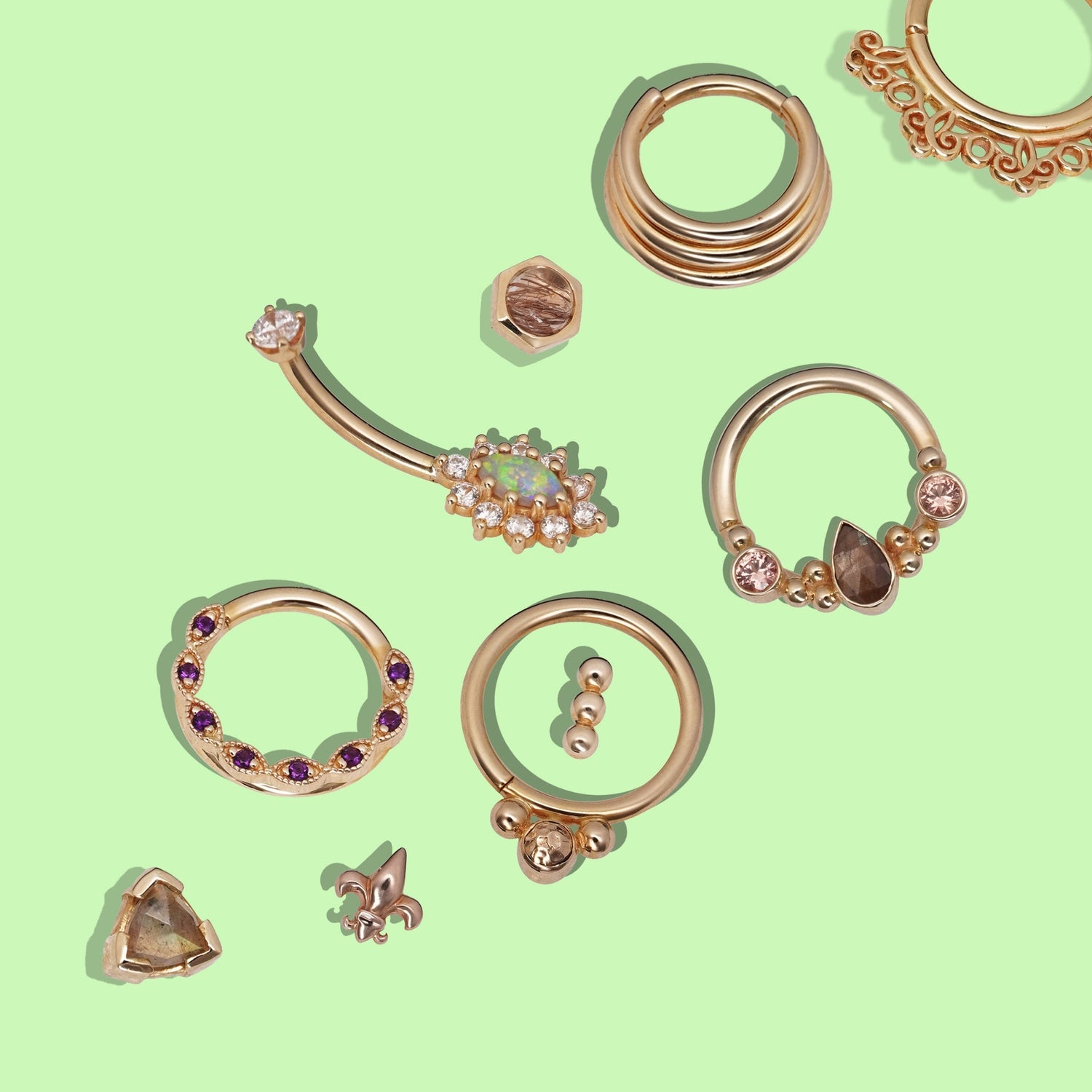 A variety of gold piercing jewelry from BVLA. gold seam rings, clickers, studs and curved barbells